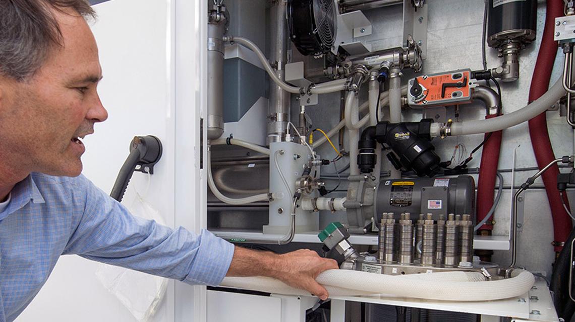 A team member demonstrates SoCalGas' power-to-gas project